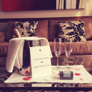 Une bouteille de champagne avec deux coupes dans une suite au Saint-Sulpice hôtel