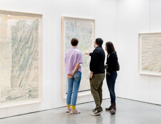 Trois personnes admirant un tableau lors de La Foire d'Art Contemporain Plural